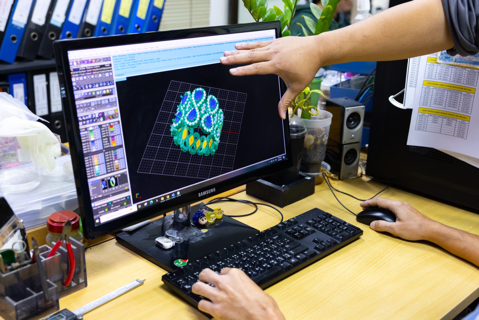Designer reviewing a 3D CAD model of a jewelry casting tree on screen
