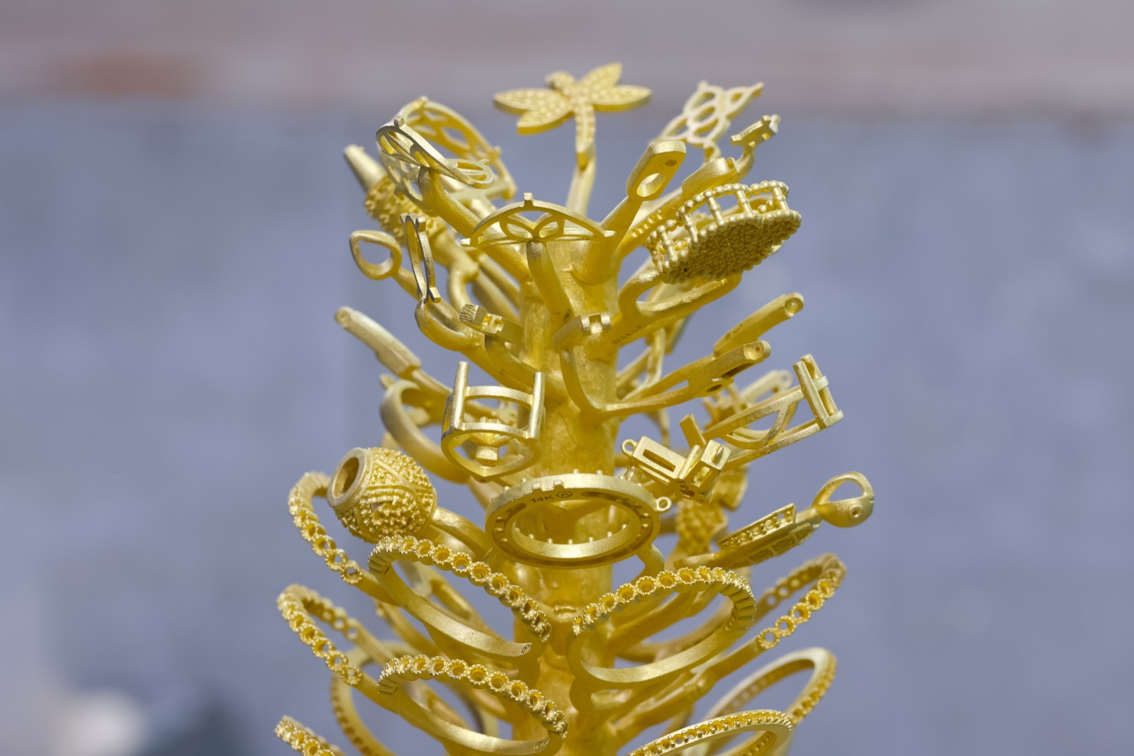 Gold casting tree with freshly cast jewelry pieces