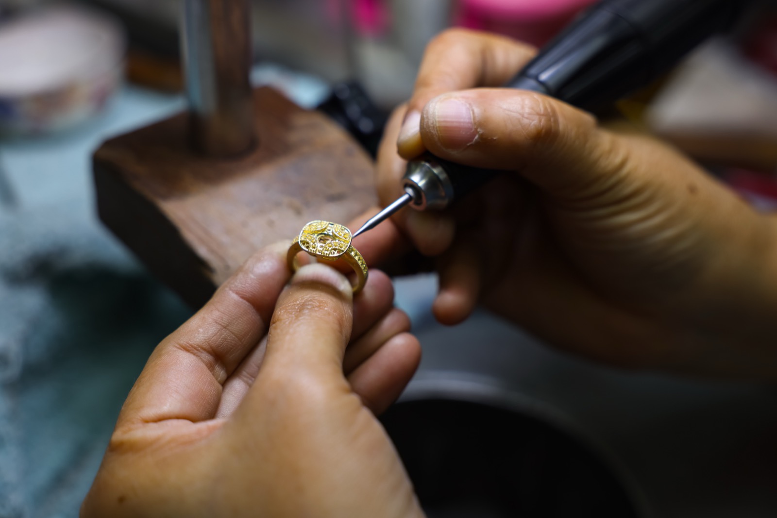 Artisan filing a gold ring by hand at the bench
